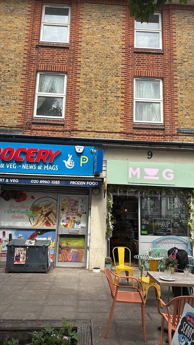 MUG's green frontage with outdoor tables beside the neighbouring grocery